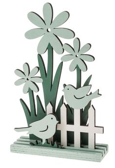 a card with flowers and birds in the grass on top of a white picket fence