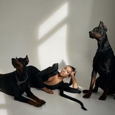 a woman laying on the ground next to two dogs