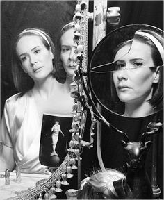 two women are looking at themselves in the mirror, with one woman's reflection