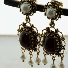 14K Yellow Gold Black Onyx and Pearl Drop Ear Pendants, 8x10mm high dome oval cabochons, 3 pearl drops with larger pearl on stud, 1 1/2 inch x 1/2 inch, baroque style, Circa 1960, 7.3 grams SKU # BB275E26 This listing contains photographs of the actual item you will receive. Our items are in excellent condition with little or no signs of wear and many are one of a kind pre-owned estate finds. Please look closely at the pictures in this listing as they are part of the product description. Please Black Pearl Drop Round Jewelry, Black Round Pearl Drop Jewelry, Antique Pearl Drop Jewelry For Evening, Antique Teardrop Cabochon Jewelry, Victorian Style Metal Clip-on Jewelry, Black Cabochon Victorian Jewelry, Victorian Black Cabochon Jewelry, Elegant Oval Cabochon Clip-on Jewelry, Classic Black Pearl Drop Jewelry