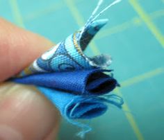 someone is stitching something blue on a piece of fabric