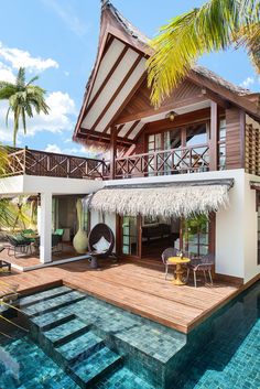 a house that has a pool in front of it and some grass on the roof