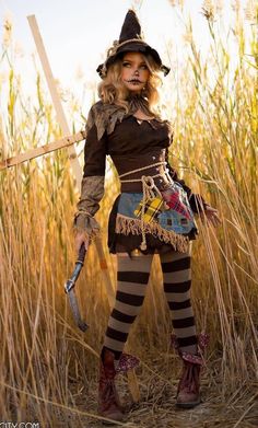 a woman dressed up as a scarecrow in a field