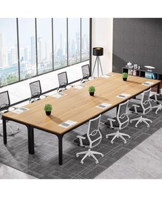 an empty conference table with chairs and plants on it in front of a large window