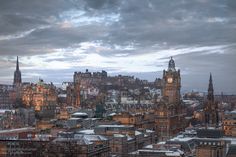 the city skyline is covered in snow at dusk, with tall buildings on either side