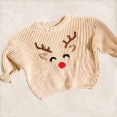 a white sweater with reindeer's drawn on it