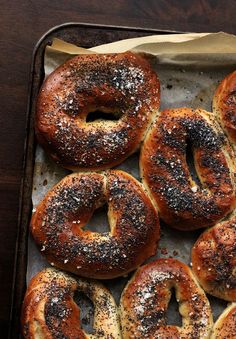 freshly baked bagels on a baking sheet ready to be served in the oven, with powdered sugar and pepper sprinkled on top