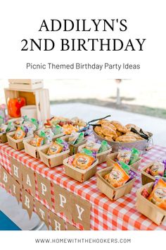 an outdoor birthday party with snacks and treats on the table, including cookies in boxes