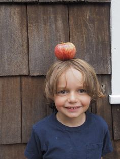 a young boy with an apple on top of his head