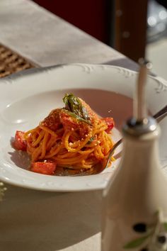 a white plate topped with spaghetti and sauce