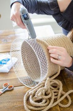 a woman is working on some kind of thing with scissors and yarn in front of her