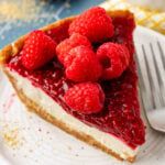 a slice of cheesecake with raspberries on top