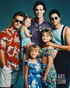 a group of people standing next to each other in front of a blue wall with sunglasses on