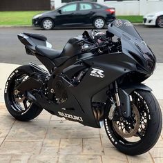 a black motorcycle parked on top of a sidewalk