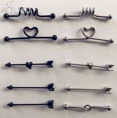 several different types of metal pins with hearts and arrows on each one, all lined up in the same row