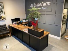 an office desk with a plant on it in front of the state farm building sign