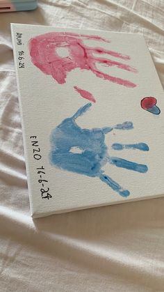 a book with hand prints on it sitting on a bed