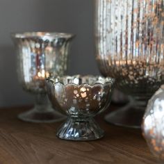 some glass bowls and candles on a table