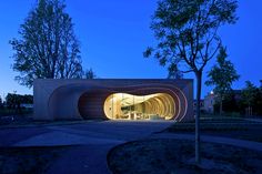 a building that is made out of concrete and has a circular entrance at the top