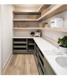 an image of a kitchen with wooden floors and shelvings on the wall above it