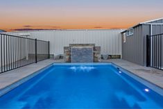 an empty swimming pool in the middle of a backyard with fenced in areas around it