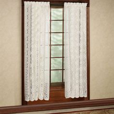 an open window with white lace curtains