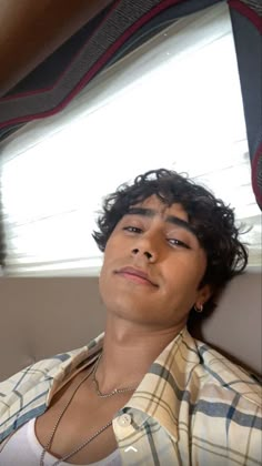 a young man sitting in the back seat of a car looking off into the distance