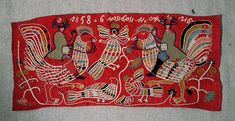 an old embroidered cloth with birds and roosters on it's side, hanging from the wall