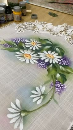 the table cloth has flowers on it and is next to some other paintbrushes