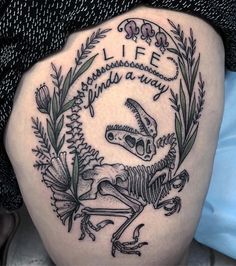 a black and white photo of a tattoo on the back of a woman's thigh