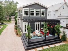 a house with a covered patio in front of it and lots of plants on the deck