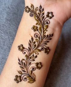 a woman's hand with a hendi design on the wrist and armband