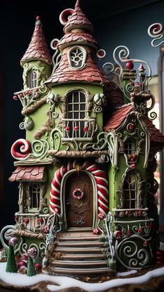 a green and red christmas house on top of a table