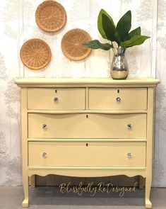 a yellow dresser with three wicker plates above it