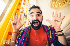 a man with his hands in the air and two fingers raised up to spell out something