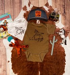 This darling I'm a Foal for You bodysuit is the perfect way to show off your little one's western-inspired style. The brown cotton blend fabric features an adorable foal, with ‘I'm a Foal for You’ script handwriting. Plus, this cute piece of baby apparel is proudly made in Texas! Western Baby Girls, Girl Hunting, Baby Cowgirl, Western Baby Clothes, Western Kids, Clothes Country, Script Handwriting, Cowboy Shop, Cowboy Accessories