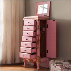 a pink dresser with drawers and mirror on top