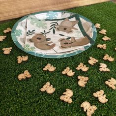 a paper plate with some cut out koalas on it sitting in the grass