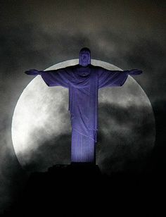 the statue of christ in front of a full moon