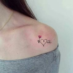 a woman with a small tattoo on her shoulder that says i love you in the center