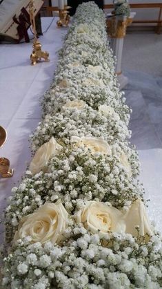 a long table with white flowers and candles on the top is set up for a formal function