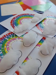 rainbows and clouds are cut out from paper with colored pencils on the table