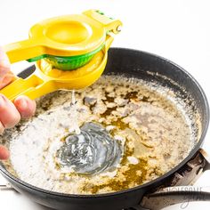 a person is adding oil to a frying pan