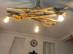 a light fixture made out of wood sticks and lights hanging from it's ceiling