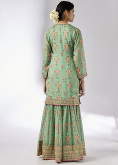 This pretty ensemble in our floral jaal, with an intricate border embroidery. The short tunic with matching dupatta embroidered in sequins and gold thread, and voluminous sharara adds a feminine grace. Embroidered Sharara For Reception With Straight Kurta, Embroidered Sharara With Straight Kurta For Reception, Anarkali Palazzo Set In Pista Green With Floral Embroidery, Pista Green Anarkali Palazzo Set With Floral Embroidery, Transitional Anarkali Palazzo Set With Floral Embroidery, Festive Anarkali Palazzo Set With Floral Embroidery, Designer Floral Embroidered Sharara For Transitional Season, Designer Floral Embroidery Sharara For Transitional Season, Festive Chanderi Sharara With Floral Embroidery