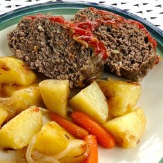 meatloaf, potatoes and carrots are on a plate with ketchup