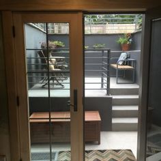 an open door leading to a patio with stairs and potted plants on the other side