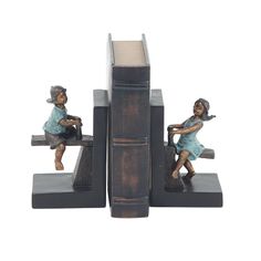 three bookends with figurines of children sitting on books, one holding a tennis racket