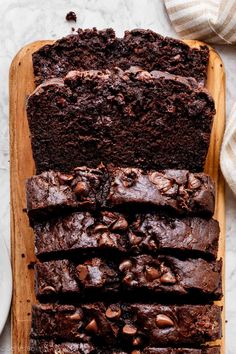 slices of chocolate cake sitting on top of a wooden cutting board