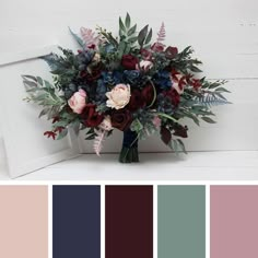 a vase filled with flowers and greenery on top of a wooden table next to a white frame